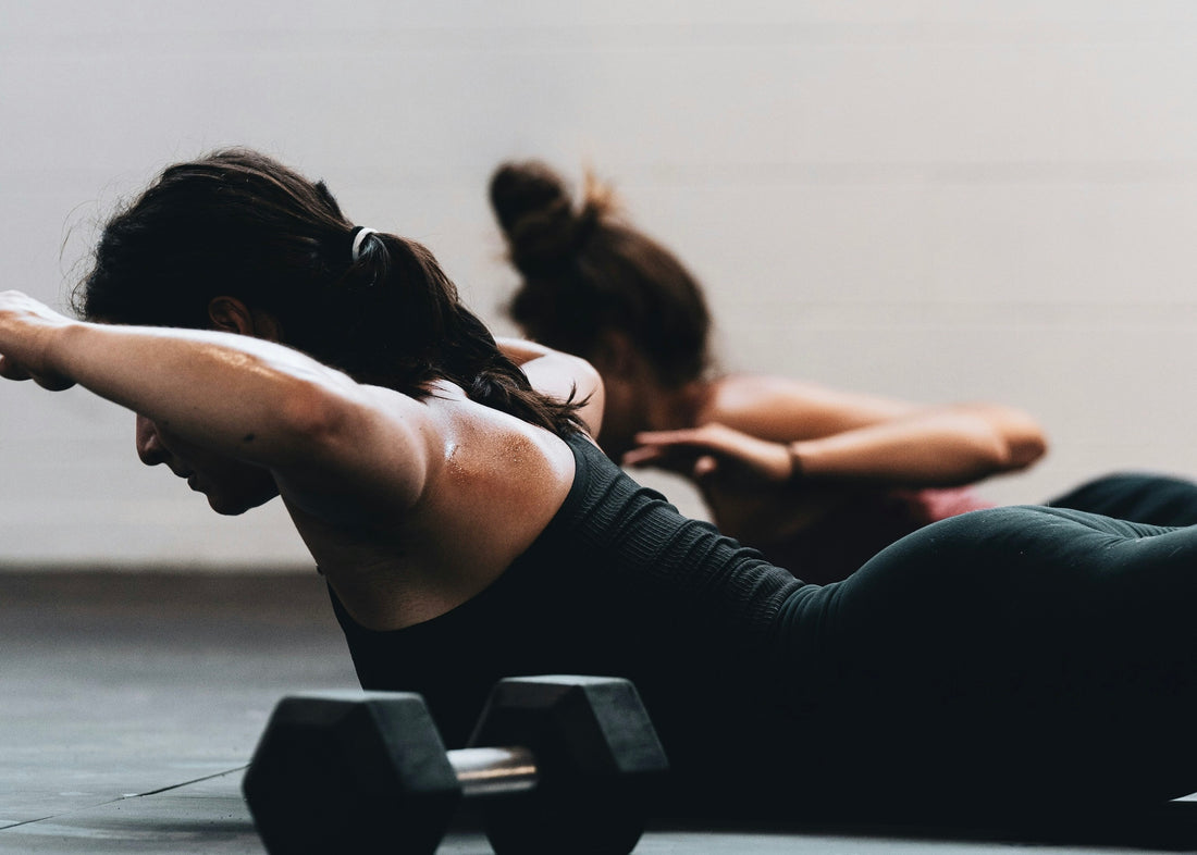 Women doing back-extension exercises with dumbbells — resistance training to protect muscle on GLP-1