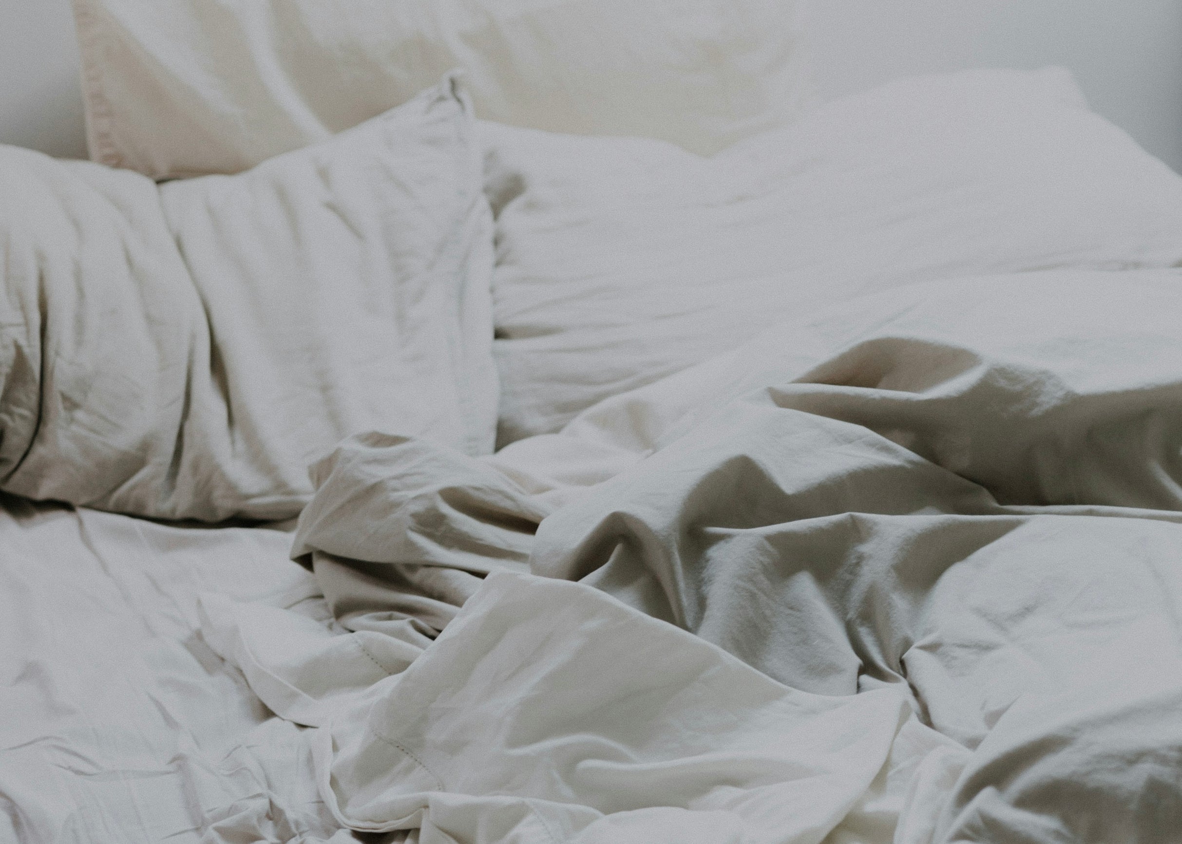 Rumpled cream linen bedsheets — the disrupted sleep of perimenopause